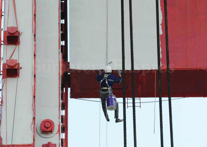 BEKERJA TANPA CEMAS-Seorang pekerja sedang melakukan pengecatan salah satu menara Jembatan Ampera Palembang  di atas ketinggian 63 Meter. Sabtu, (22/07/2023). Pekerja tersebut menggunakan APD lengkap, full body harness sebagai syarat wajib bagi pekerja yang bekerja di atas ketinggian. Sehingga pekerja dapat beaktivitas dengan tenang tanpa cemas dengan hasil yang maksimal.  Foto : Budiman/Sumateraekspres.id