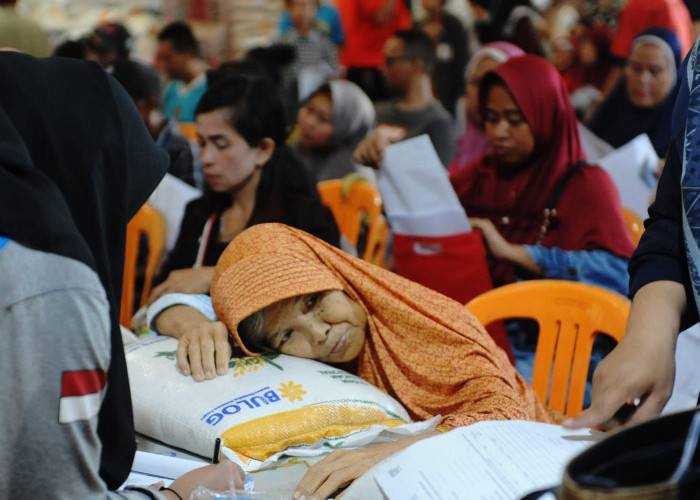 Rela Digendong Demi Bansos Beras 10 Kg-Perjuangan  Ibu  Lanjut Usia Aminah beralamat Kelurahan Sentosa Plaju Palembang yang rela digendong keluarganya demi mendapatkan Bantuan Sosial (Bansos) Beras 10 Kg dari Pemerintah di Kantor Pos Merdeka Palembang. Adapun penyebab ibu Aminah harus digendong karena dalam keadaan sakit. Sabtu. (2/3/2024). Foto:Budiman/Sumateraekspres.id