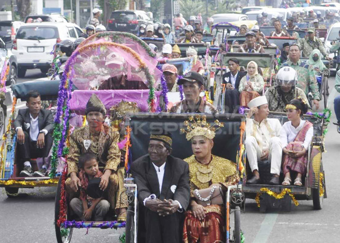 DIARAK PAKAI BECAK-Ratusan pasangan Nikah Massal Pemkot Palembang di arak menggunakan becak dari Kantor Wali Kota menuju rumah dinas Wali Kota Palembang dan diiringi Marchimband. Kamis,  (30/11/2023). Peserta Nikah Massal ini telah melakukan akad nikah di kantor Pengadilan  negeri Agama  Klas IA Palembang beberapa hari yang lalu. Foto : Budiman/Sumateraekspres.id